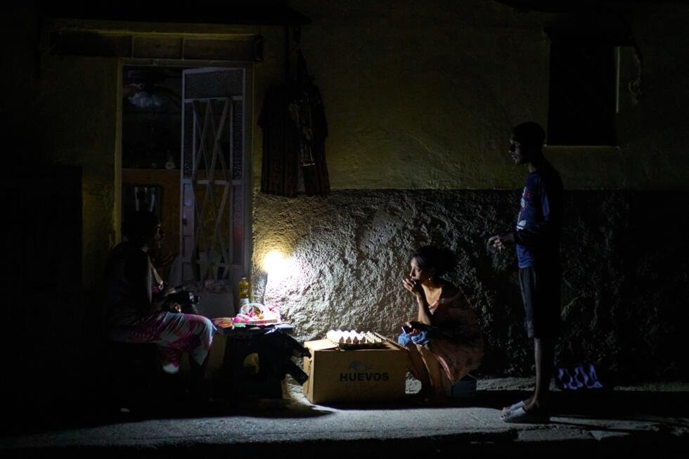 Vendedores callejeros ofrecen su mercancía iluminados con celulares en medio de un apagón en La Habana el 16 de marzo de 2026.