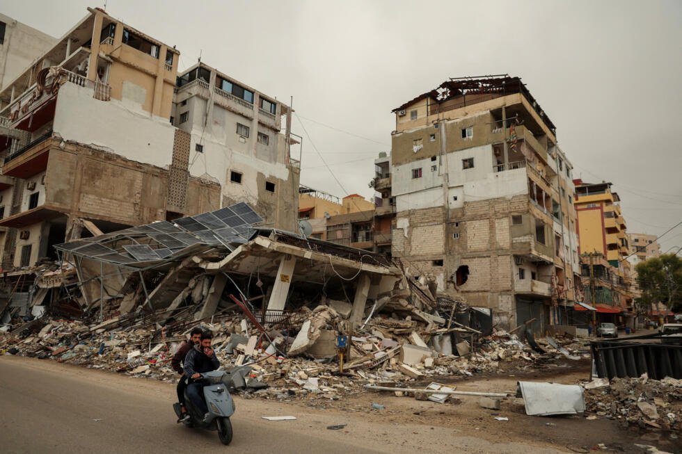 Des hommes passent en scooter devant les décombres d'un immeuble détruit par une frappe israélienne, alors que les hostilités s'intensifient entre Israël et le Hezbollah, à Tyr, au Liban, le 2 avril 2