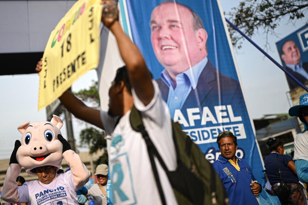 Unos partidarios del candidato a la presidencia de Perú Rafael López Aliaga, del partido Renovación Popular, esperan su llegada a un acto en el distrito de San Juan de Lurigancho, a las afueras de Lima, el 15 de marzo de 2026