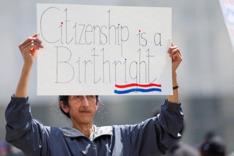 Tanjam Jacobson sostiene una pancarta mientras la gente protesta el día en que los jueces de la Corte Suprema escuchan los argumentos orales sobre el intento del presidente estadounidense Donald Trump de hacer cumplir ampliamente su orden ejecutiva para restringir la ciudadanía automática por derecho de nacimiento, frente a la Corte Suprema de los Estados Unidos en Washington, D.C., EE. UU.